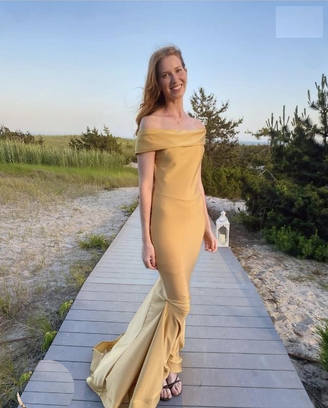 Kate Broderick in a gold dress on a boardwalk.